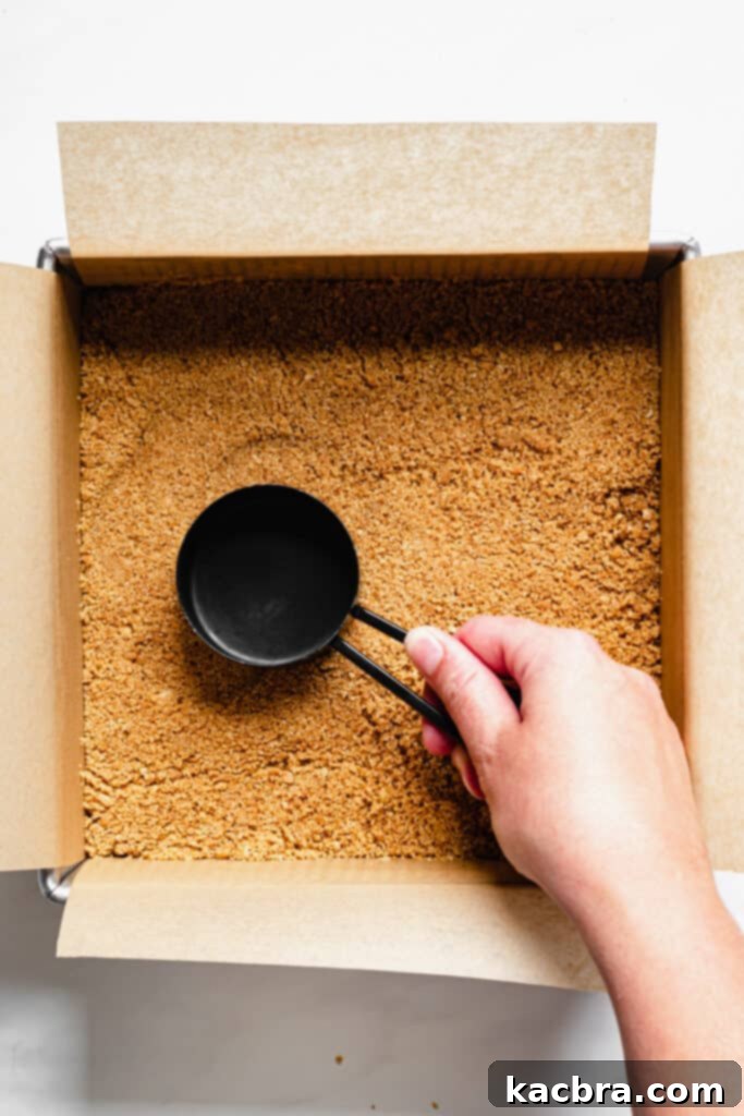 Baked graham cracker crust in a square pan.