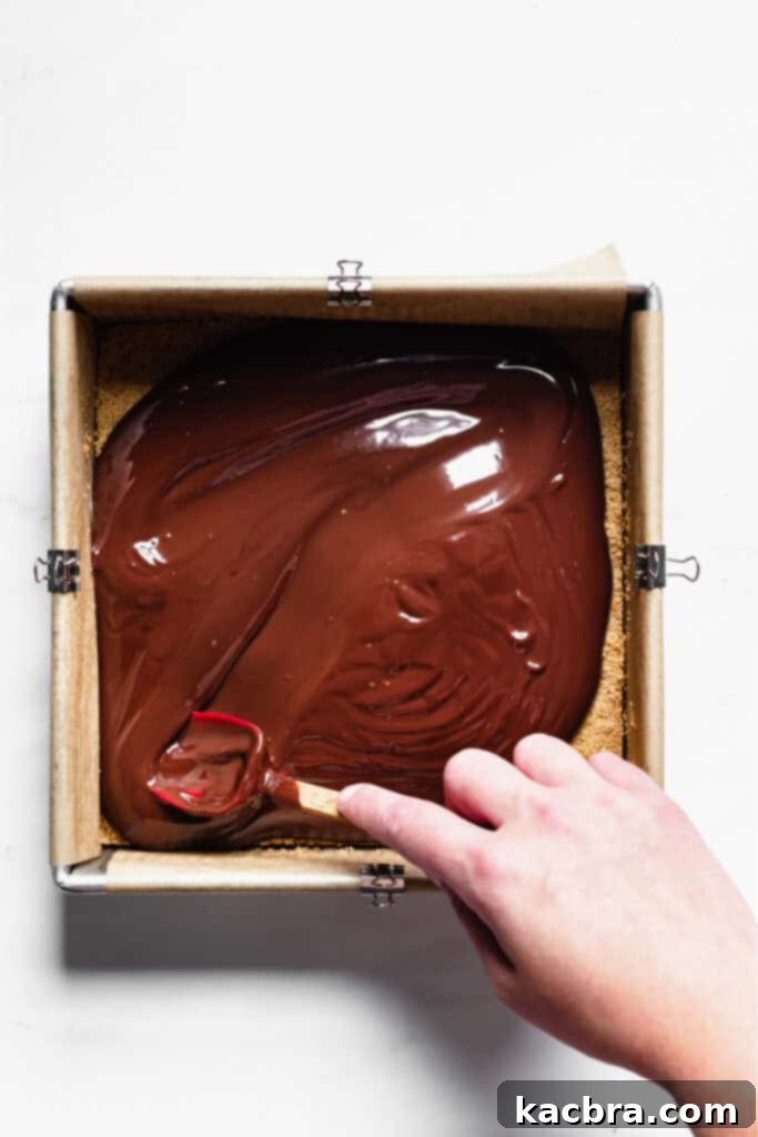 Smooth chocolate ganache spread over graham cracker crust.