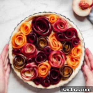 Completed stone fruit tart with roses shot from overhead, beautifully glazed and ready to serve.