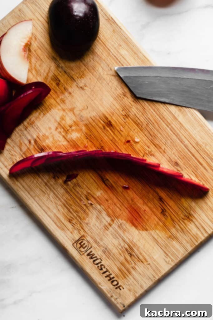 Fanning out stone fruit slices on a cutting board, step 2.