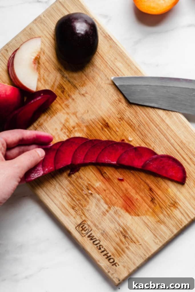 Beginning to roll stone fruit slices into a tight spiral, step 3.