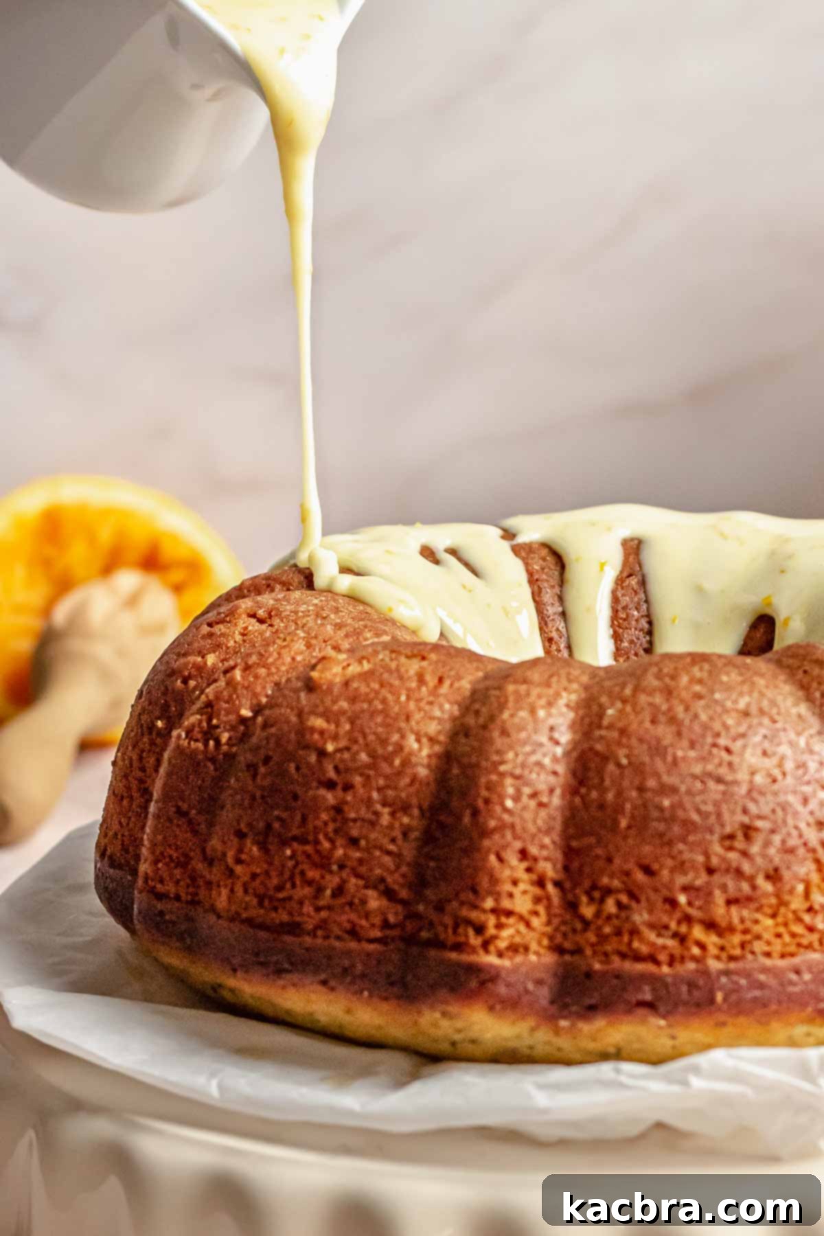 Icing being poured onto the orange poppy seed Bundt Cake.