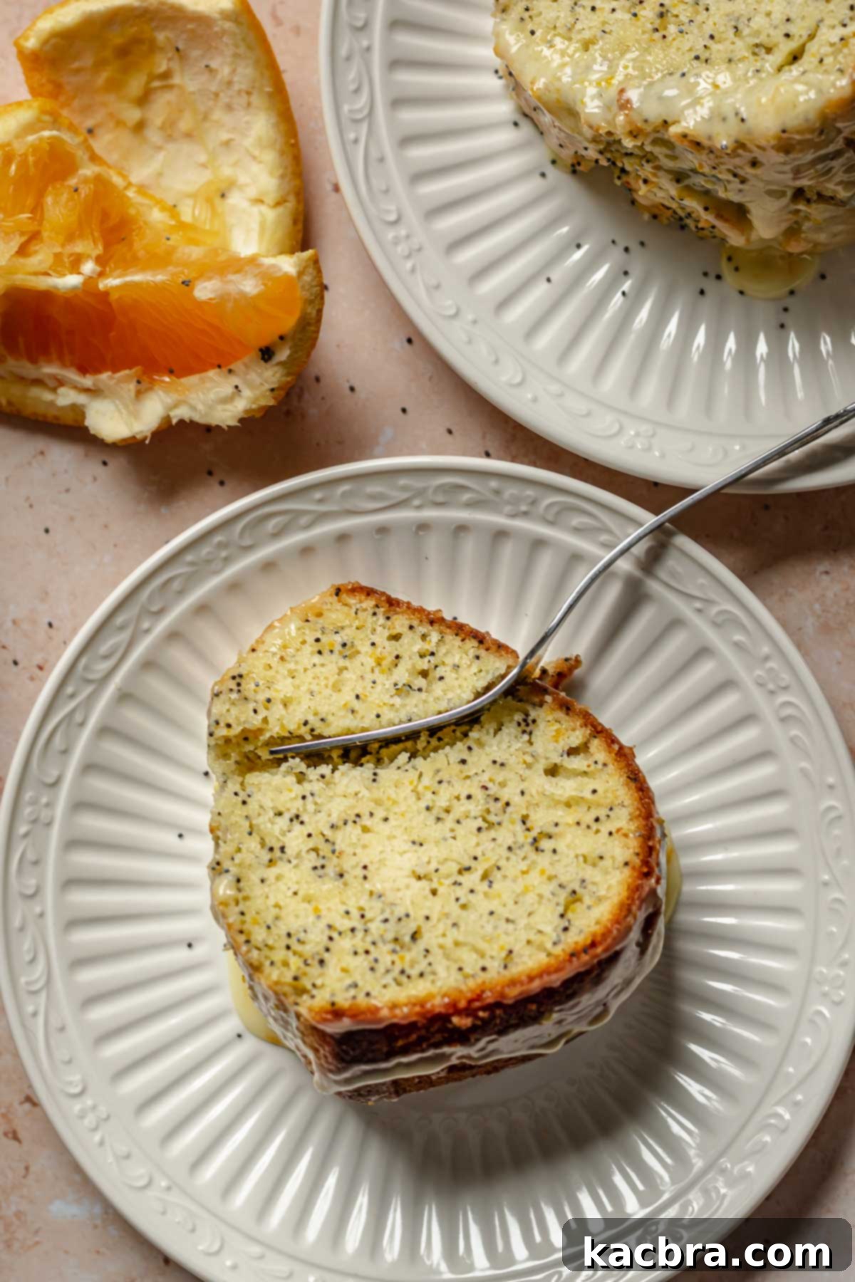 Two plates with slices of cake on them. A fork cuts into one.