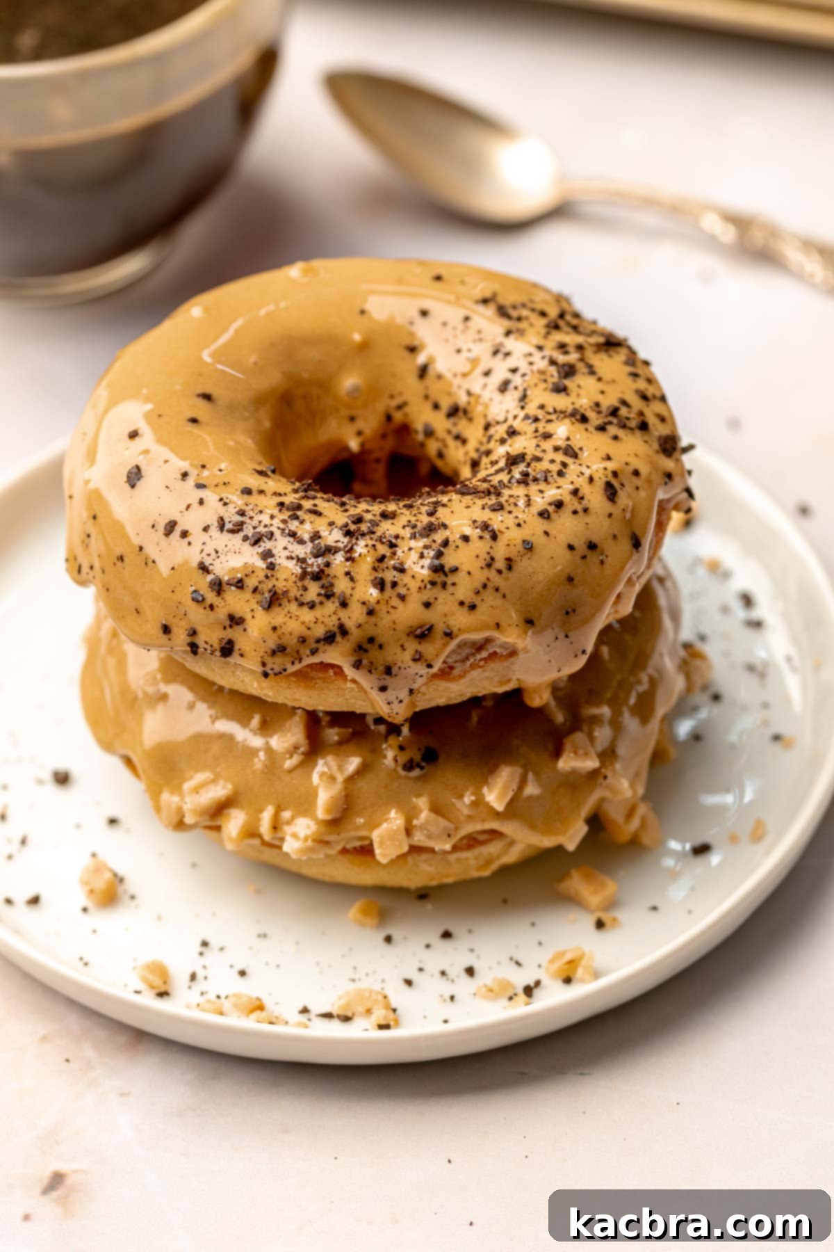 A stack of coffee donuts on a plate, ready to be enjoyed with a cup of coffee.