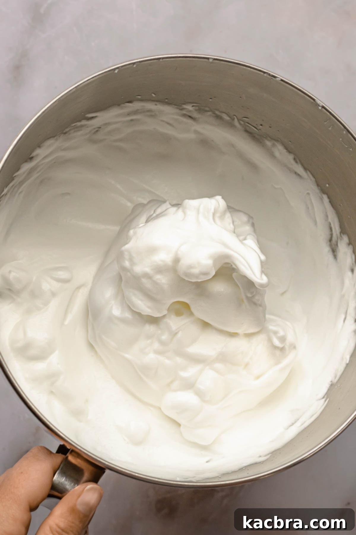A bowl of stiffly whipped egg whites, ready for folding into cake batter.