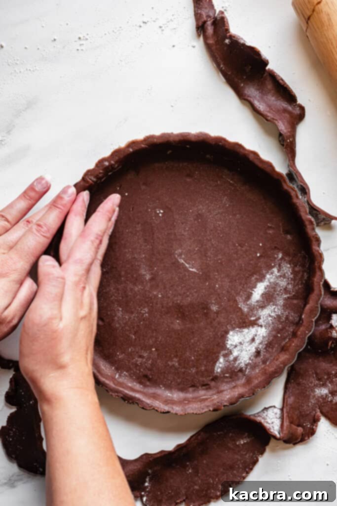 Trimming excess chocolate tart dough with a rolling pin