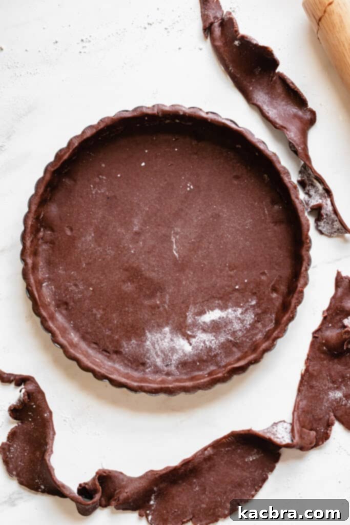 Chocolate tart dough docked with a fork before blind baking