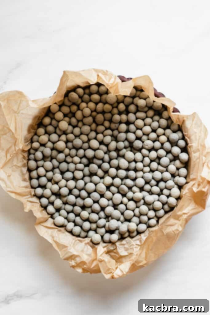 Filling chocolate tart shell with pie weights for blind baking