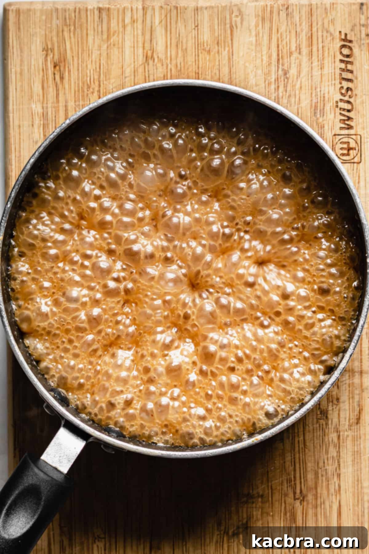 Decadent Caramel Pecan Cheesecake 14 Bubbling apple cider caramel sauce reaching its final stage, indicating it's ready for the addition of salt and cinnamon.