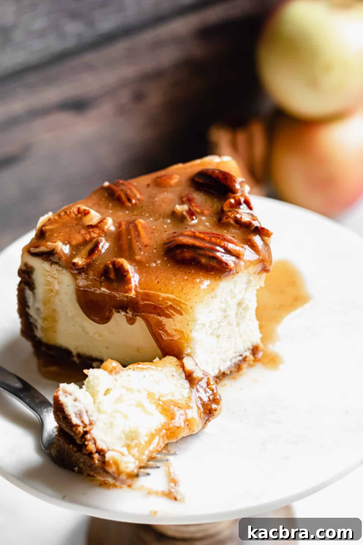 Decadent Caramel Pecan Cheesecake 17 A single slice of caramel pecan cheesecake on a fork, with a bite removed, highlighting its rich layers and irresistible texture.
