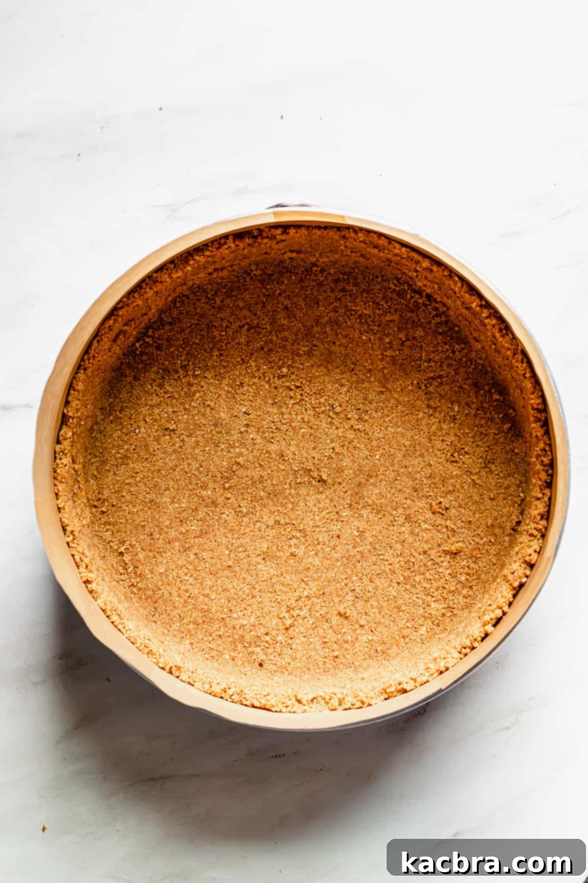 Decadent Caramel Pecan Cheesecake 6 A perfectly formed graham cracker pecan crust pressed into the bottom and sides of a springform pan, ready for baking.