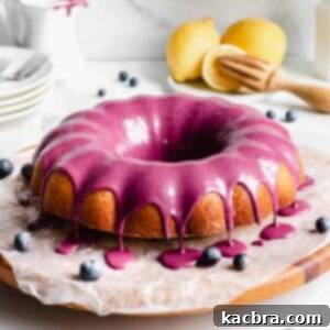 Velvet Lemon Ricotta with Bursting Blueberry Glaze 11 A straight on shot of lemon pound cake with blueberry glaze dripping over the edges of the cake