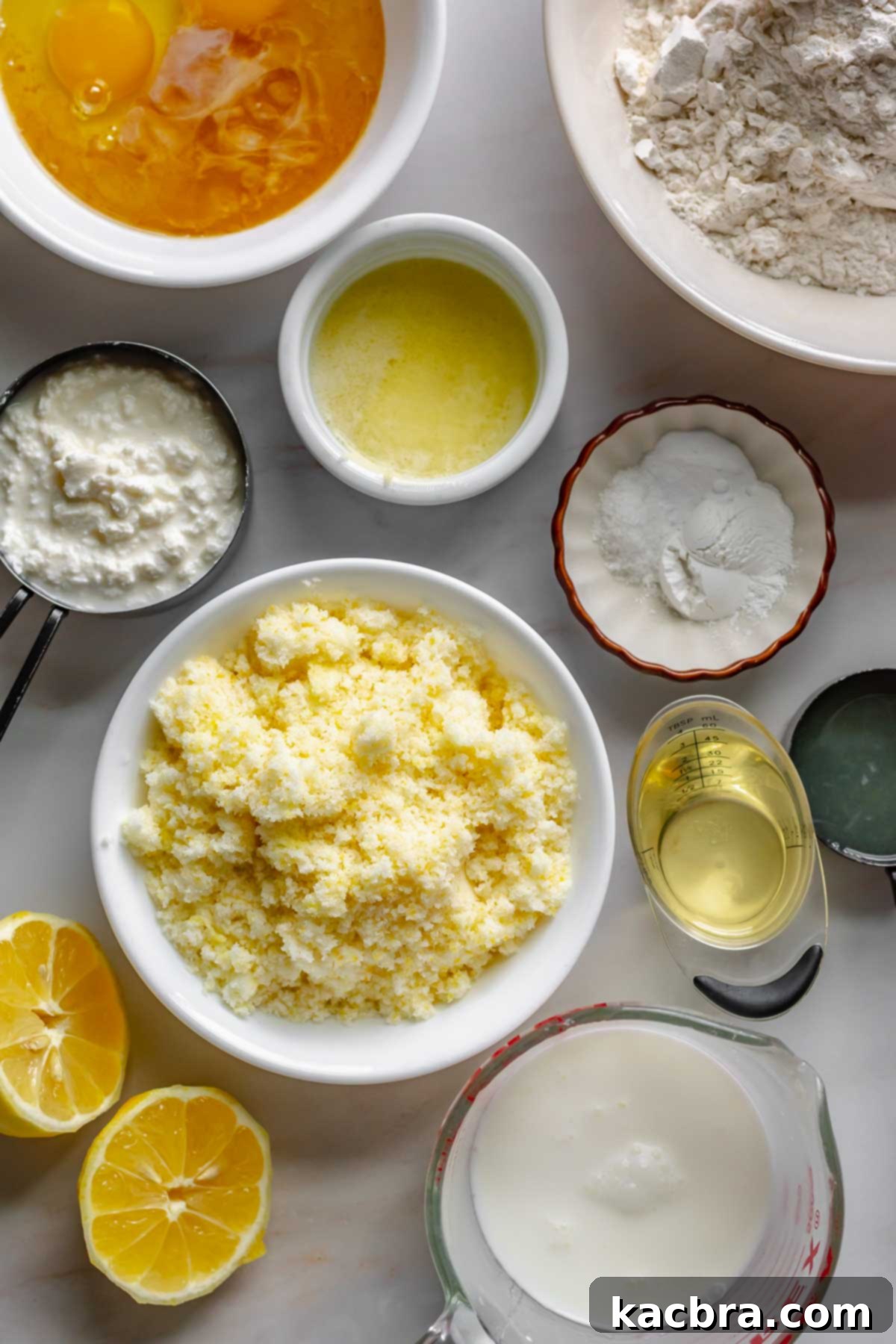 Velvet Lemon Ricotta with Bursting Blueberry Glaze 3 Various ingredients for the lemon ricotta cake including eggs, flour, ricotta cheese, butter, baking powder, baking soda, lemon zest, sugar, oil, milk, and fresh lemons, neatly arranged for baking.