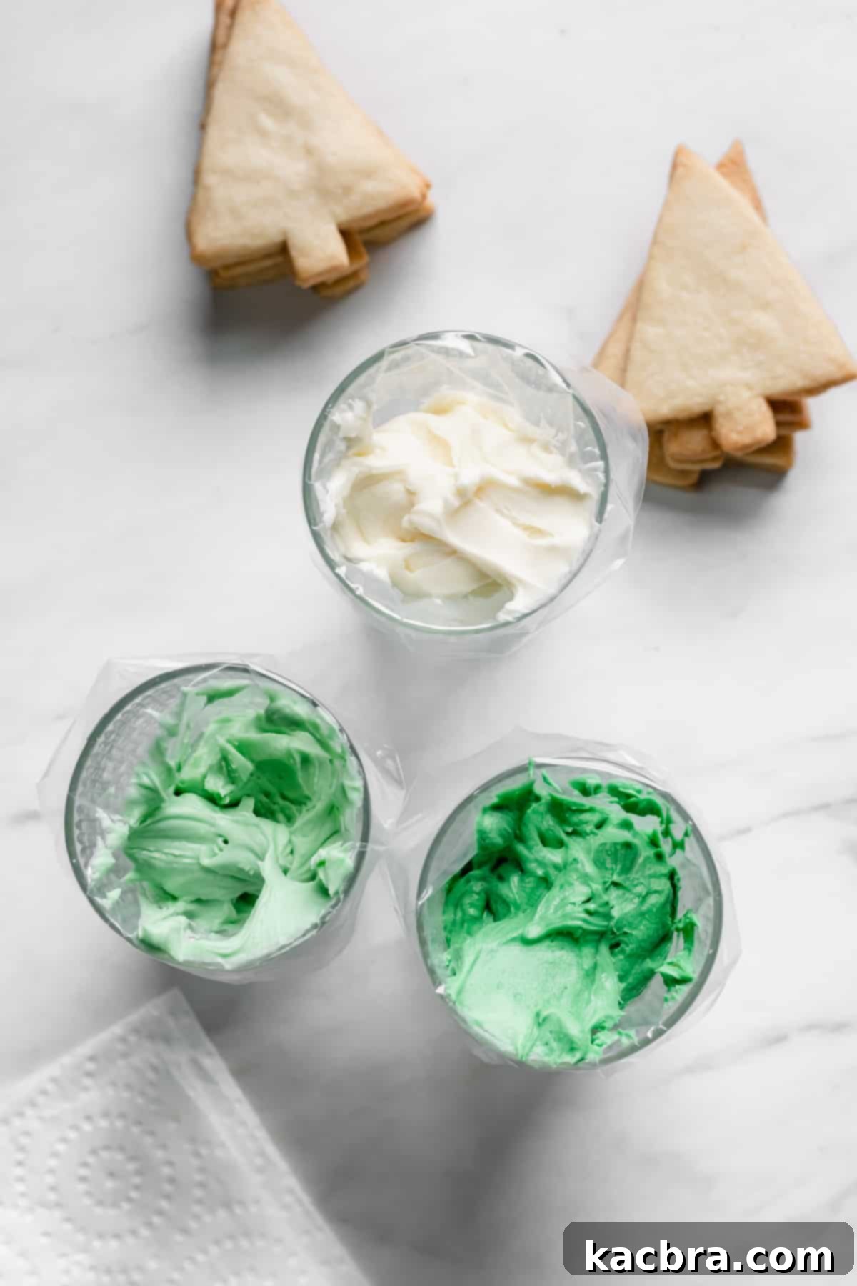 Dark green, light green, and white frosting in piping bags
