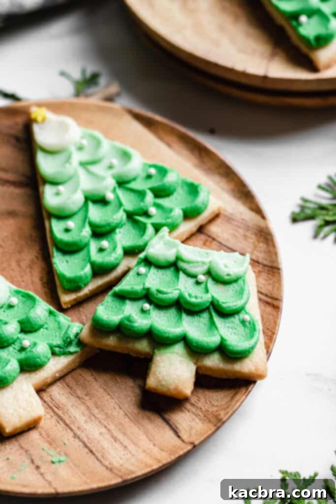 A hand holds a freshly baked Christmas tree cookie.