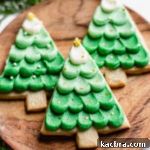 Three Christmas Shortbread Cookies on a wooden plate.