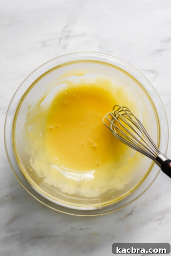 Mixing eggnog and heavy cream in a saucepan.