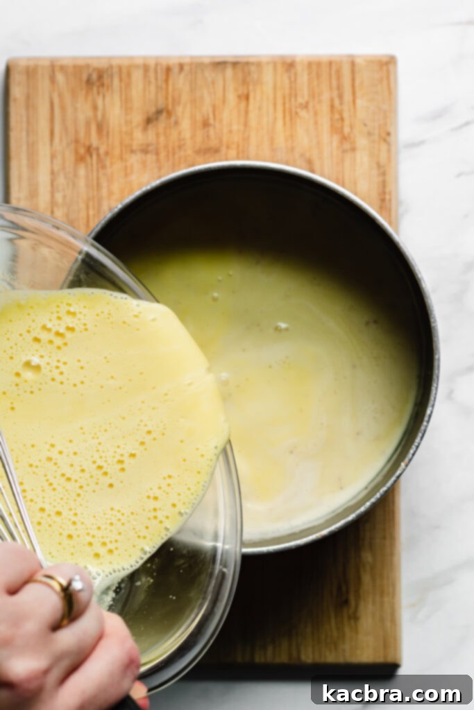 Ramekins filled with custard in a water bath.