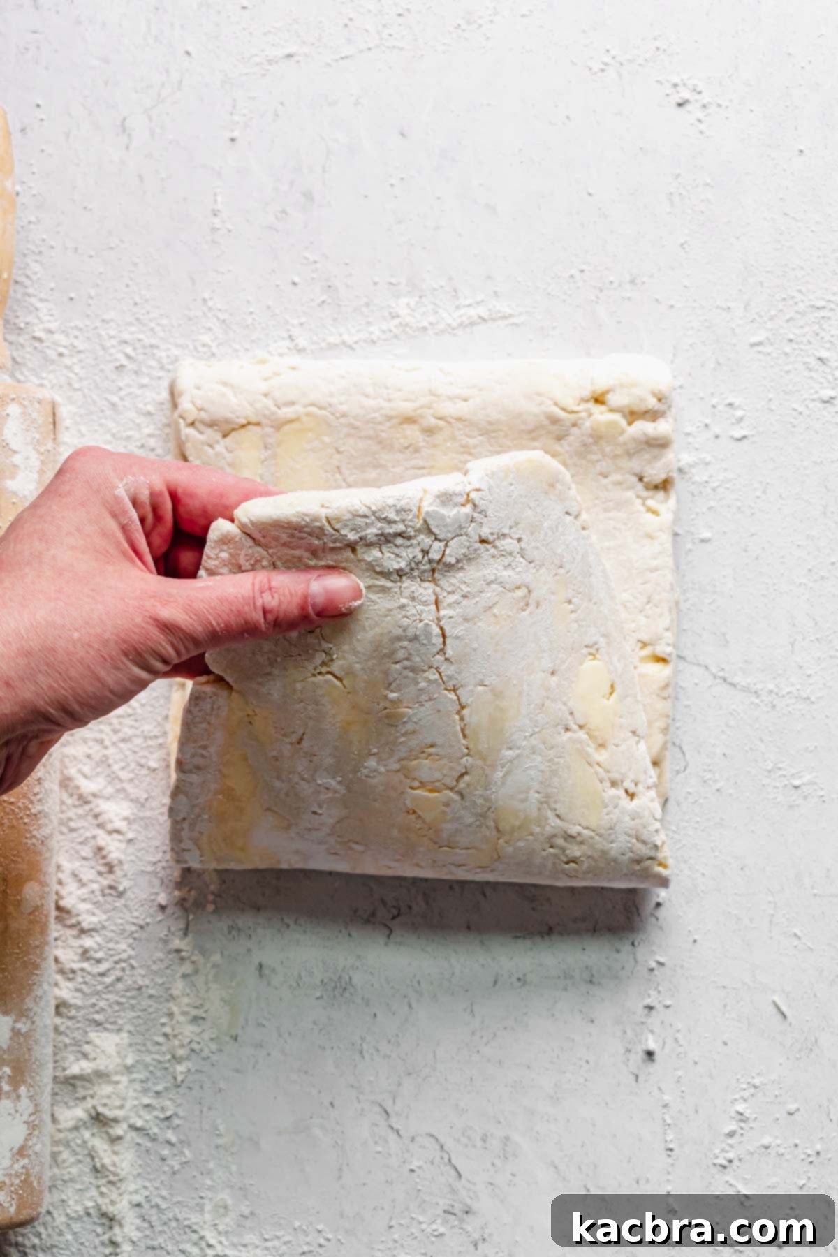 The bottom third of dough gets folded upward.