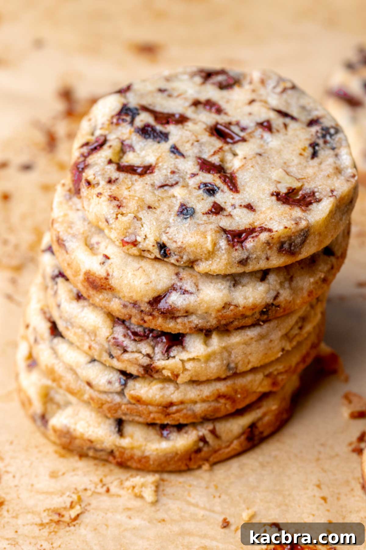 A leaning stack of perfectly round shortbread cookies, showcasing their golden color and uniform texture.