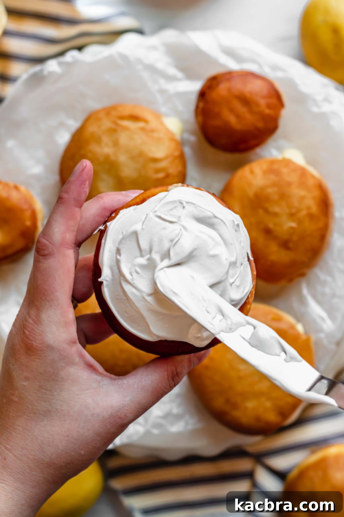 Zesty Meringue Cloud Donuts 15 Swiss meringue gets added to the top of the donut with a spatula.