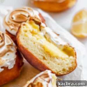 Zesty Meringue Cloud Donuts 18 Close up of a lemon filled donut cut in half to expose the lemon curd and meringue.
