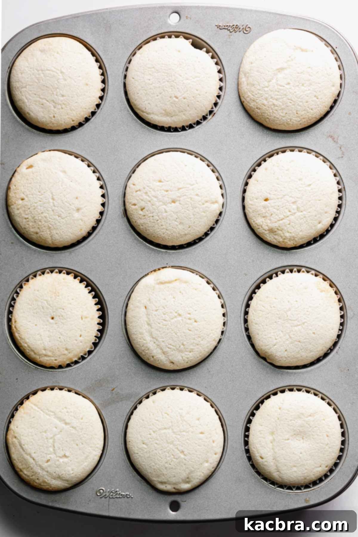 Double Strawberry Crunch Cupcakes 11 A pan of freshly baked vanilla cupcakes, risen perfectly and golden brown, cooling in their liners.