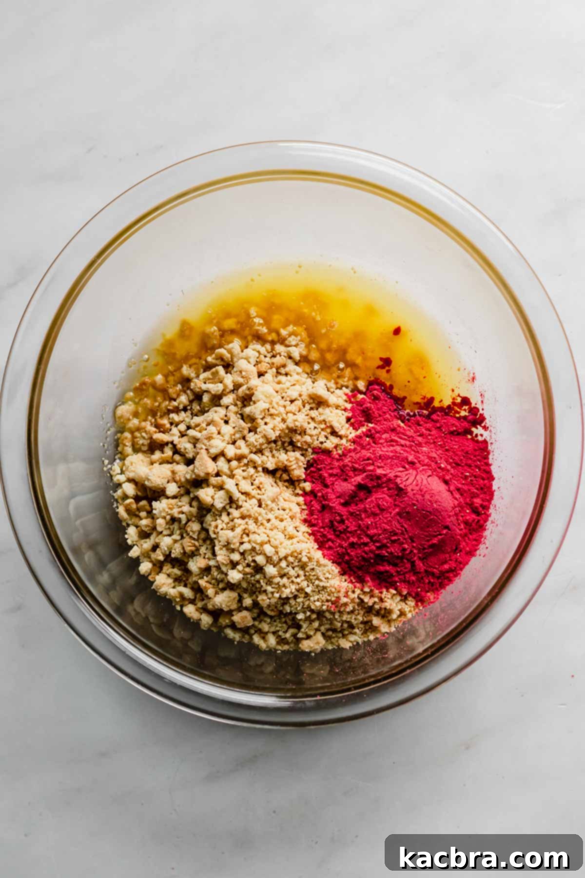 Double Strawberry Crunch Cupcakes 12 A bowl containing crushed golden vanilla cookies, vibrant freeze-dried strawberry powder, sugar, and melted butter, ready to be mixed into the strawberry crunch topping.