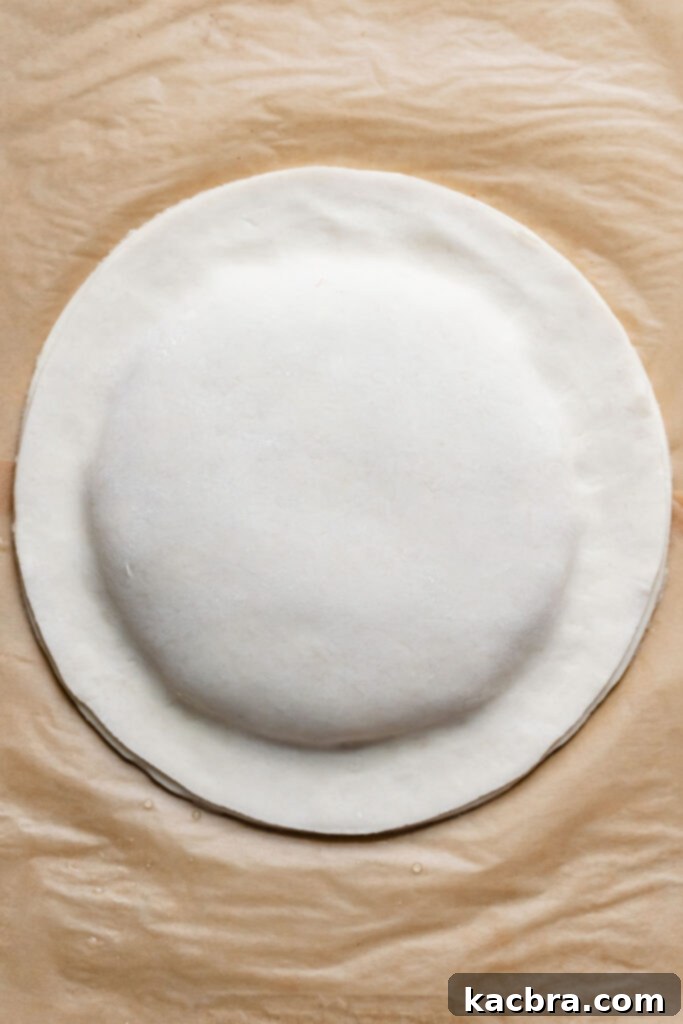 Overhead view of the two pastry rounds, firmly sealed together, with no air bubbles.