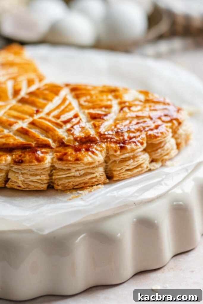 A pristine, unbaked Galette des Rois with its intricate design scored, ready for the oven.