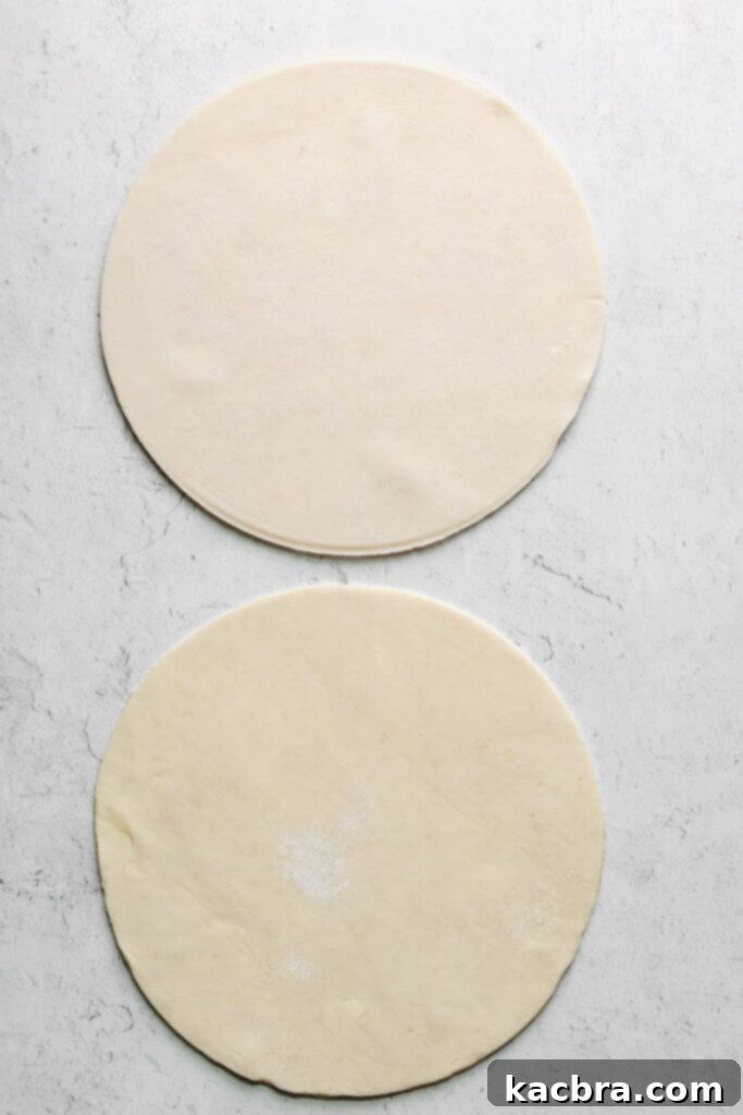 Two perfectly cut circles of rough puff pastry dough ready for assembly.