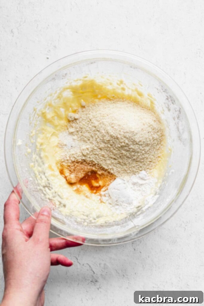 All dry ingredients for the almond cream, including almond flour, flour, and salt, are added to the creamed butter and sugar mixture.