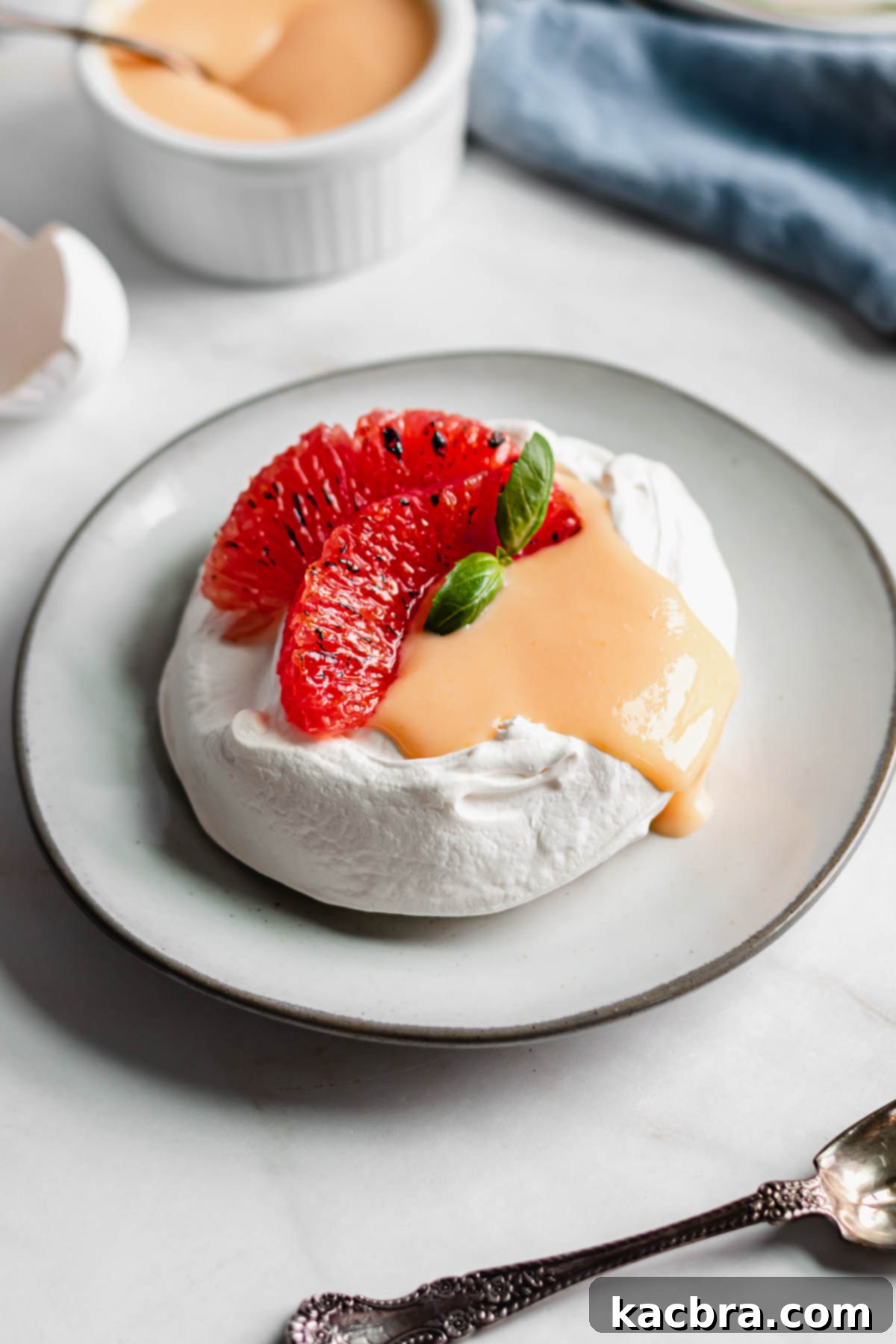 Crisp Meringue Nests with Bright Grapefruit Curd 2 Individual mini pavlova filled generously with bright grapefruit curd and garnished with two slices of fresh grapefruit. The luscious curd gently drips over the side, hinting at its juicy tang.