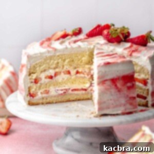 Strawberry shortcake cake sliced on a cake stand.
