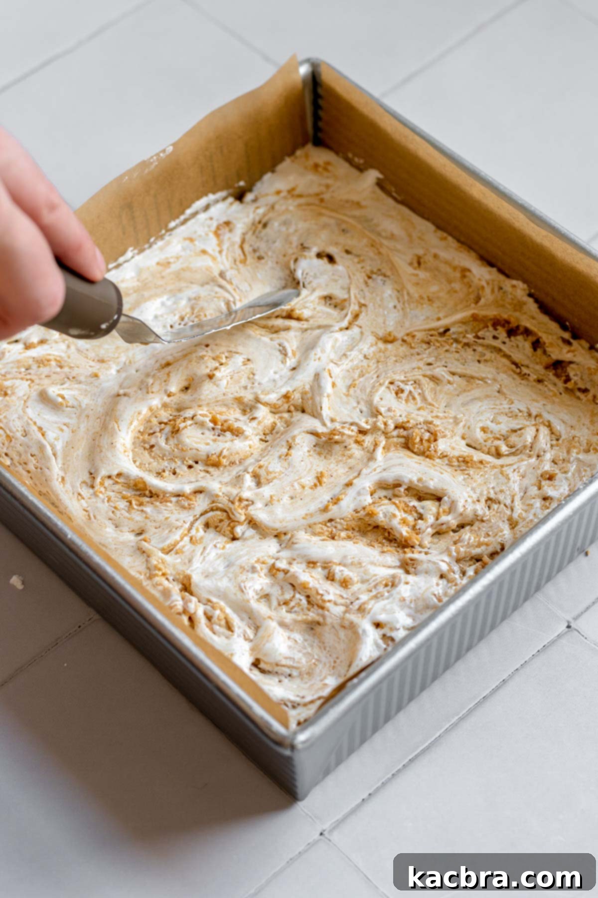 Decadent Fluffernutter Fudge 11 Marshmallow fluff being swirled into the peanut butter fudge, creating a beautiful marbled effect.