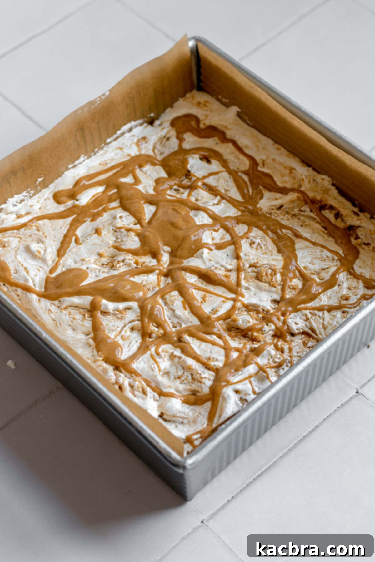 Decadent Fluffernutter Fudge 12 Melted peanut butter drizzled over the marshmallow fluff, ready for swirling.