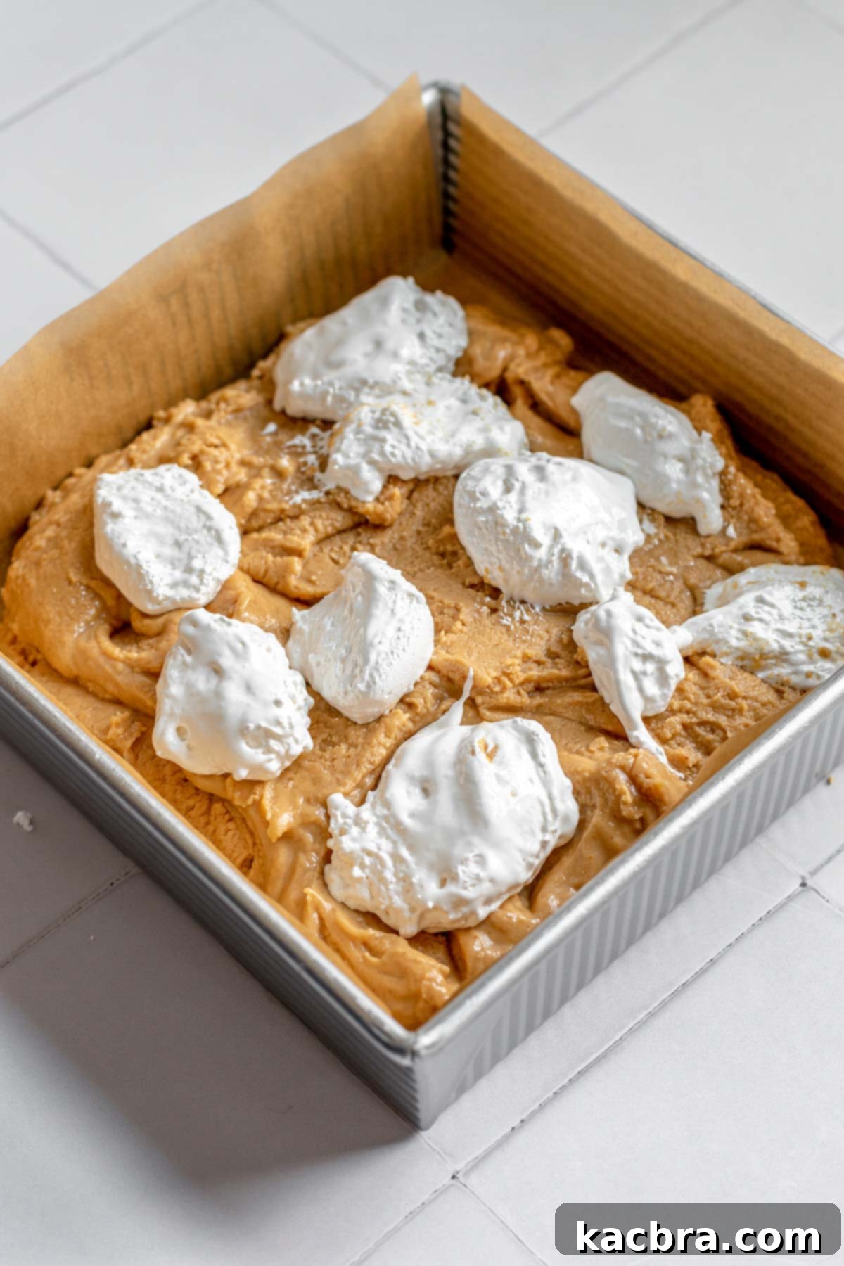 Decadent Fluffernutter Fudge 10 Dollops of marshmallow fluff arranged on top of the smooth peanut butter fudge.