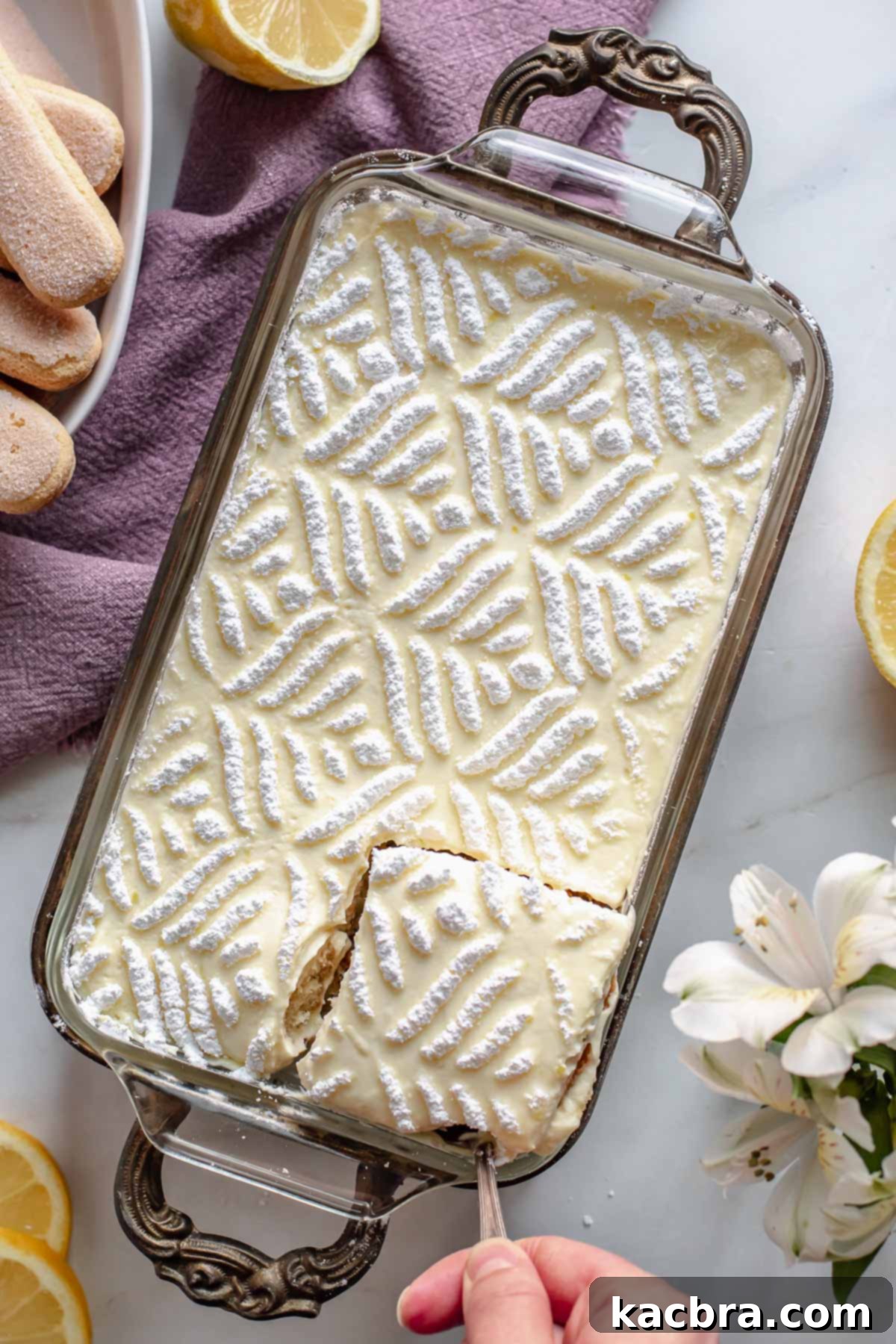 Pan of Earl Grey Tiramisu with a slice being removed, showing the clean cut layers.