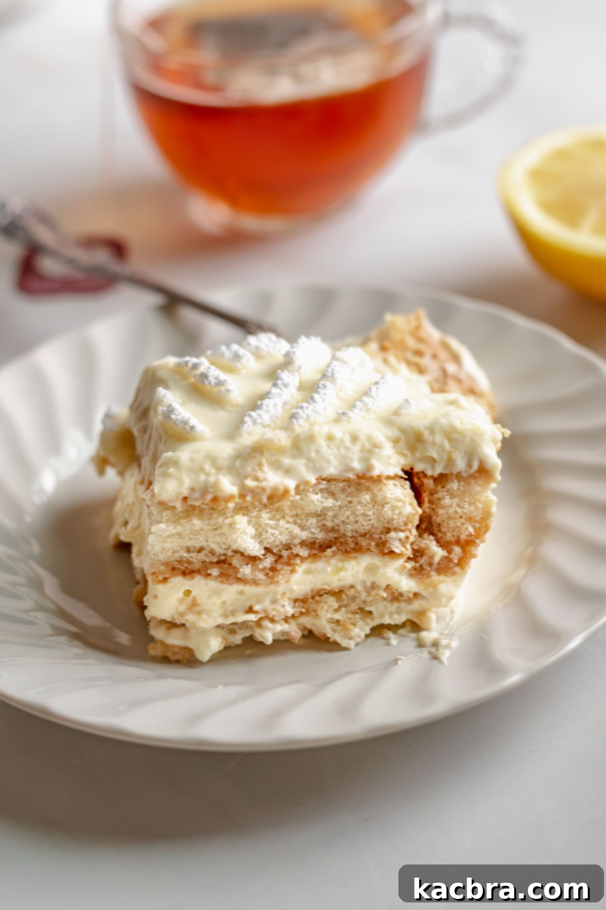 A pristine slice of Earl Grey Tiramisu on a white plate, ready to be enjoyed.