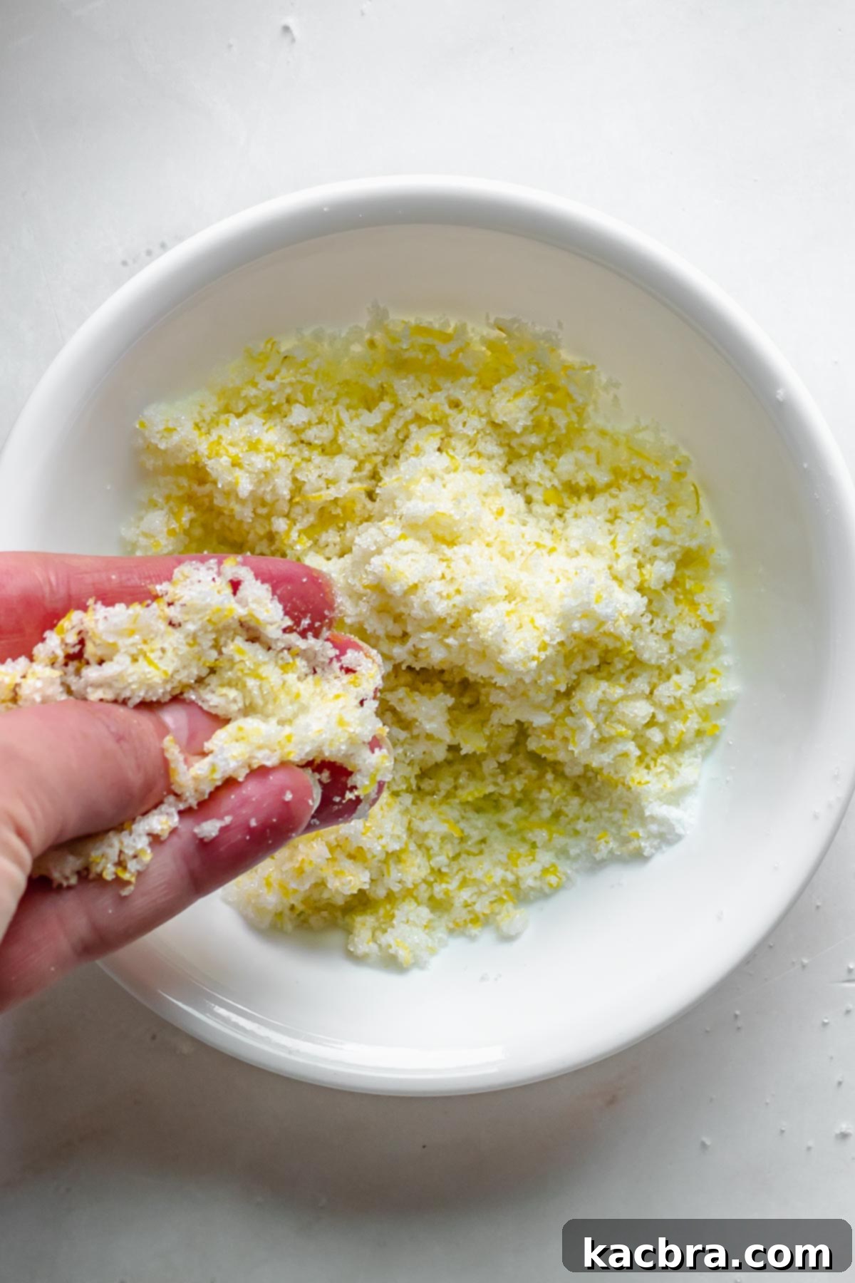 Lemon zest and sugar being rubbed together to release aromatic oils.