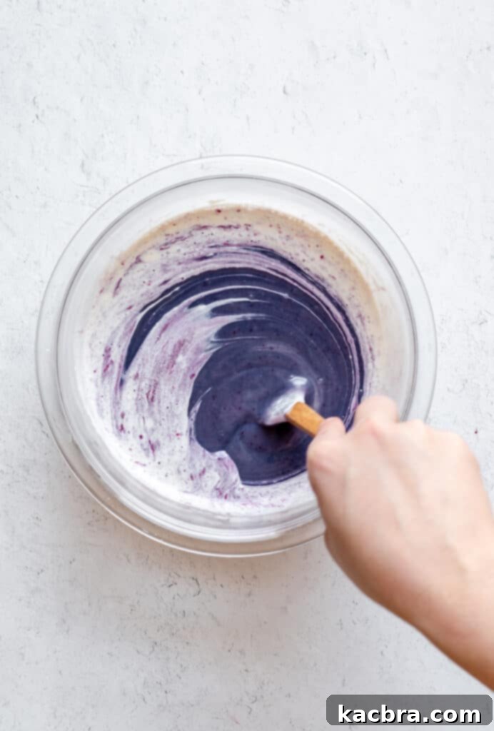 The smooth, glossy blueberry white chocolate ganache after stirring, ready to be poured into the tart shell.