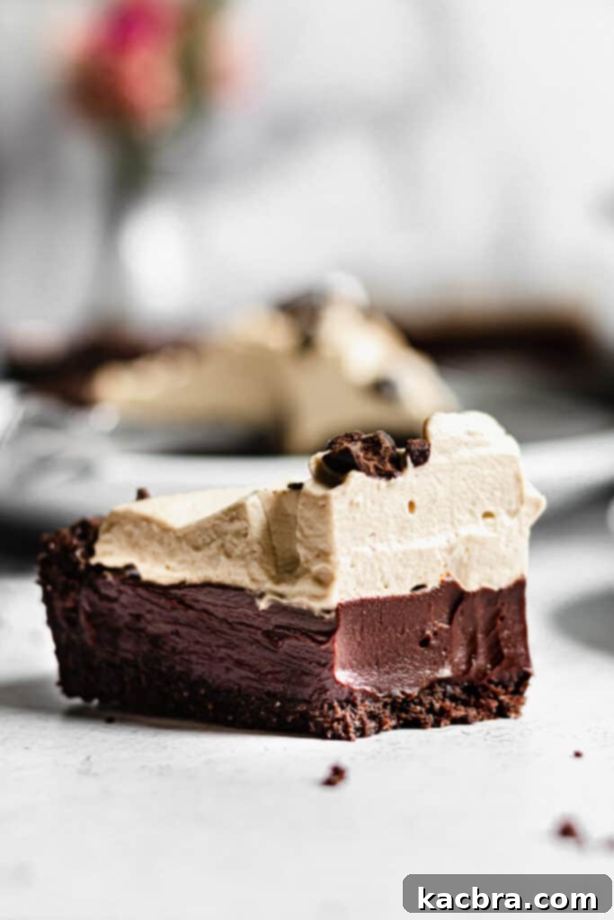 A perfectly sliced Chocolate Espresso Tart with a rich ganache filling and fluffy espresso whipped cream, garnished with chocolate-covered espresso beans.