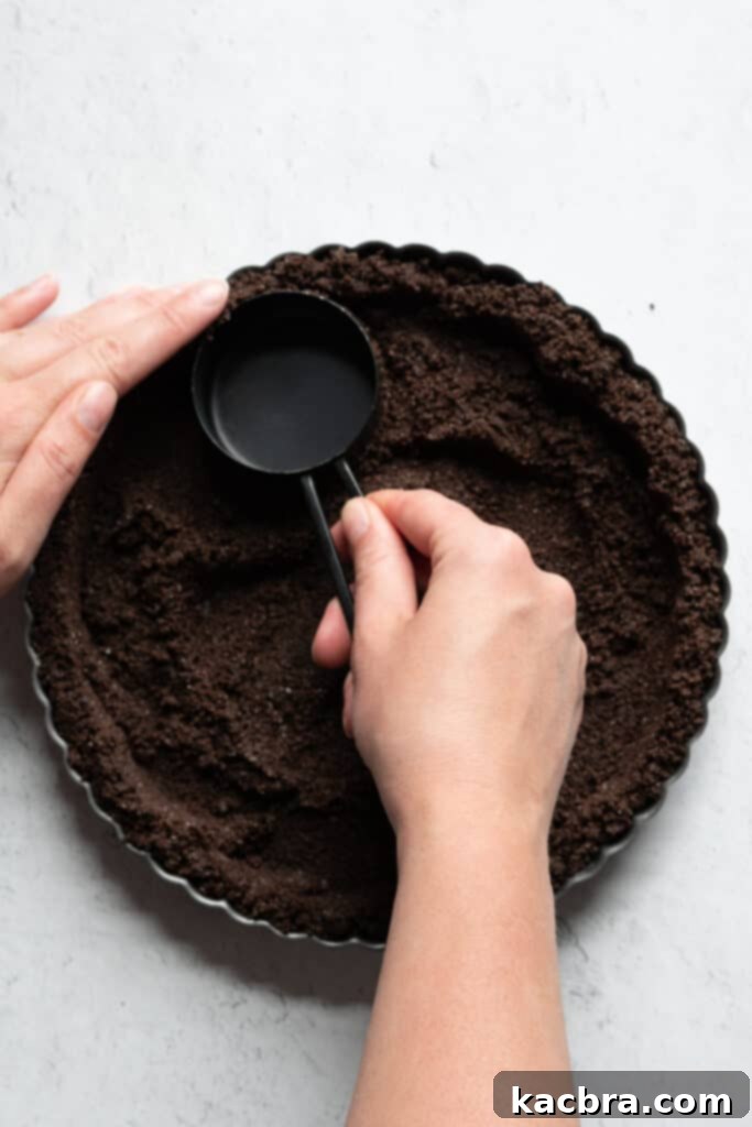 Graham cracker crumbs being mixed with melted butter and sugar in a bowl.