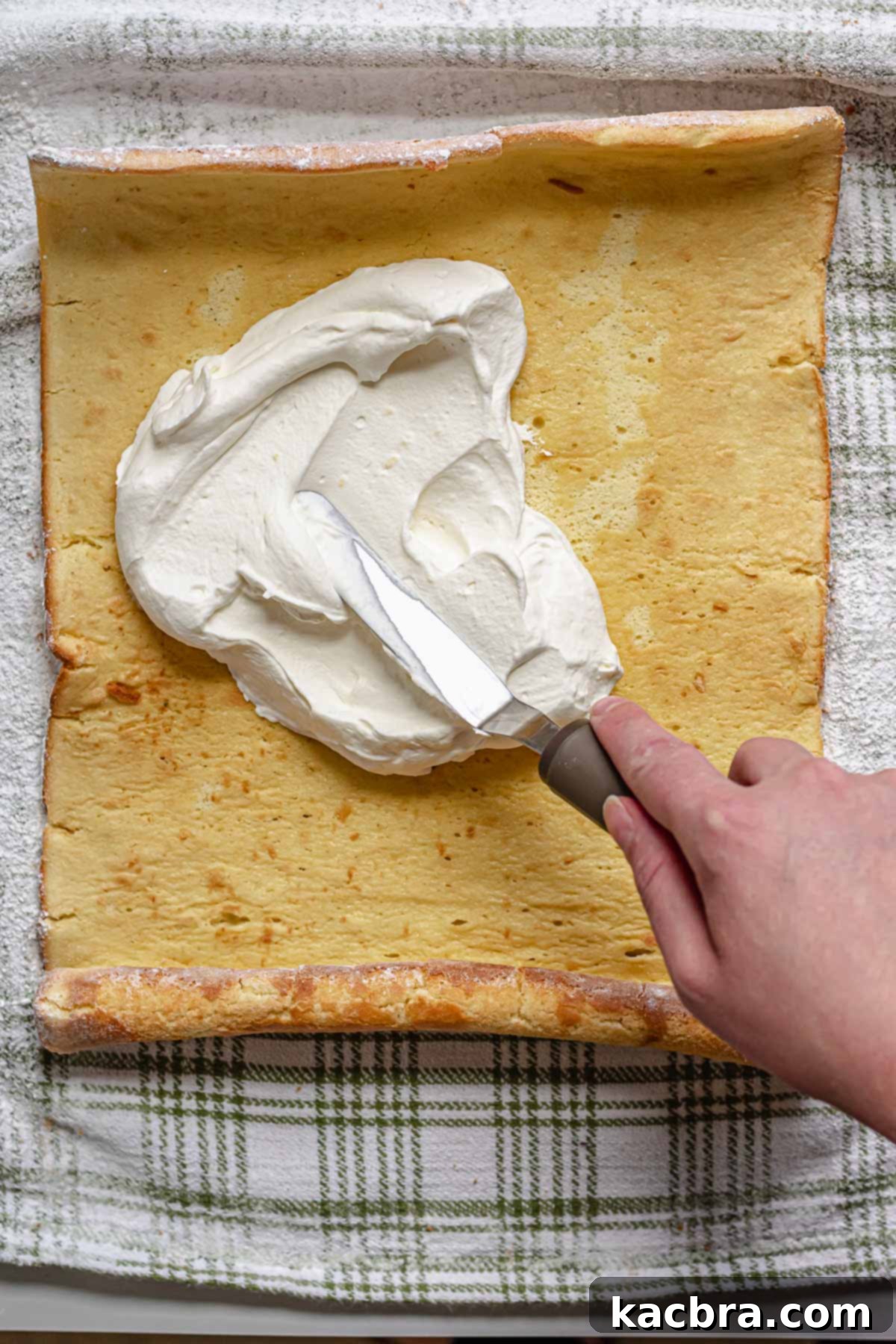 A spatula spreads on whipped cream.