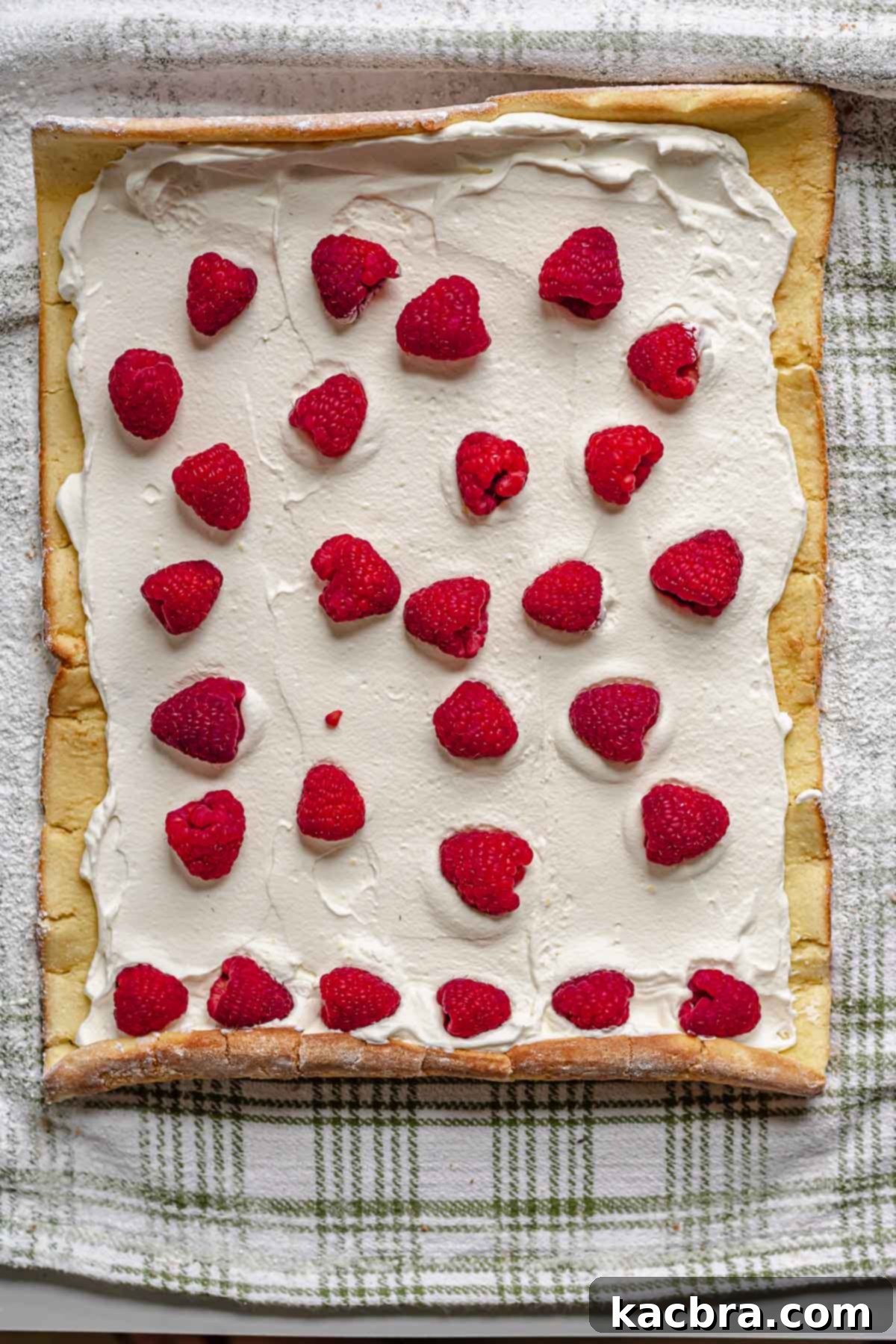 Raspberries on top of whipped cream.