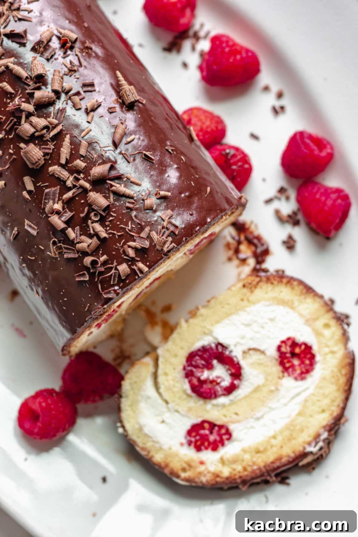 Vanilla Swiss roll with a slice laying next to the cake.