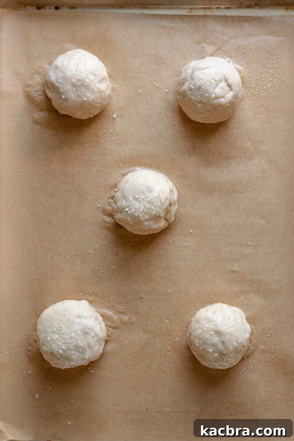 Savory Pimento Pretzel Twists 13 Boiled pretzels arranged on a baking sheet, ready for baking.