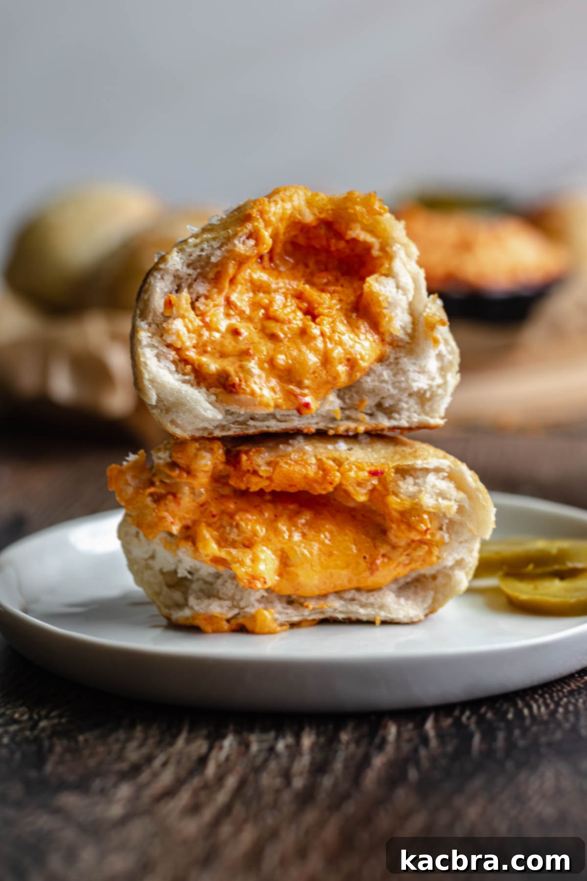 Savory Pimento Pretzel Twists 14 Two cheese stuffed pretzel bites cut in half and stacked on a white plate, showcasing the rich melted filling.