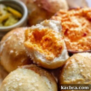 Savory Pimento Pretzel Twists 15 Mound of cheese filled pretzels with one broken in half, showing the melted cheese inside, on a serving platter.