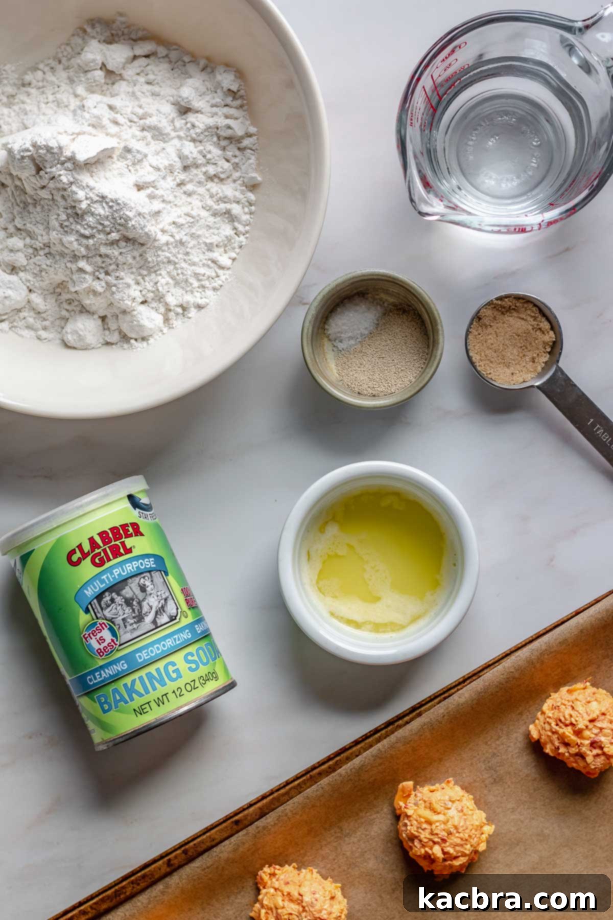 Savory Pimento Pretzel Twists 4 Various ingredients laid out for making pimento cheese stuffed pretzels, including flour, yeast, water, brown sugar, baking soda, melted butter, and frozen pimento cheese balls.